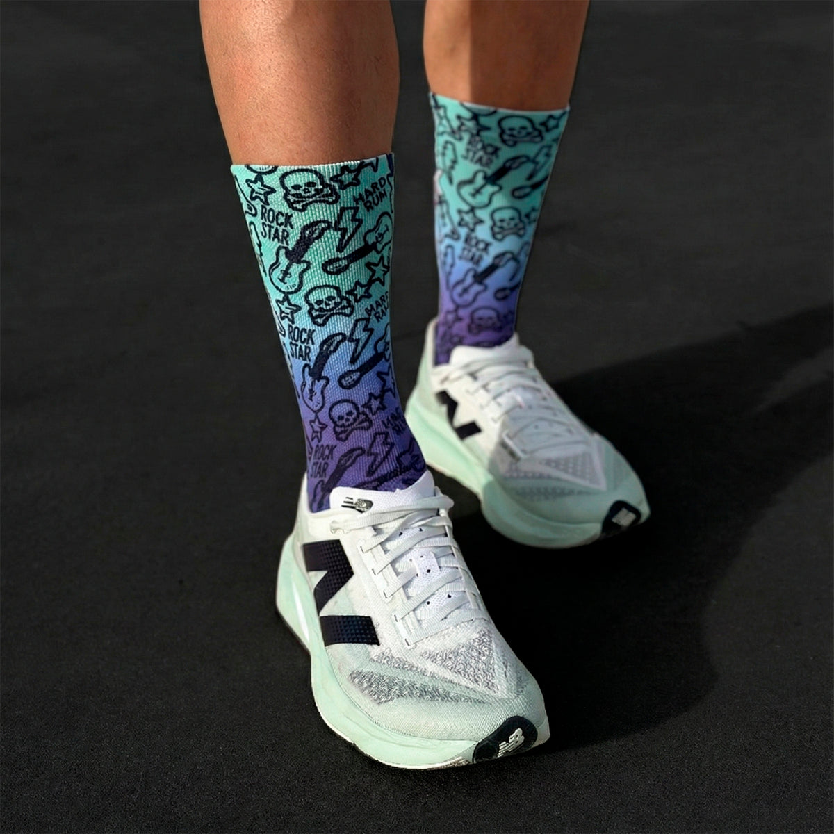 Meias técnicas e sem costura Rock & Run, design degradê azul-roxo com estampa de guitarras e caveiras.